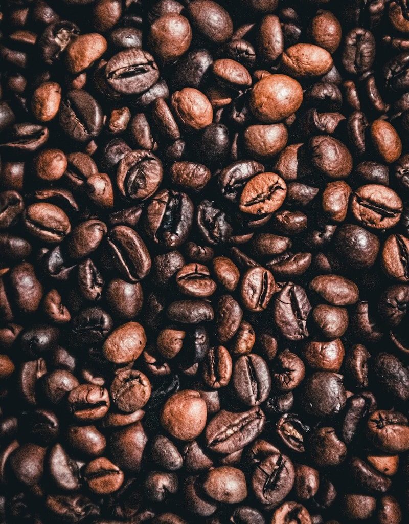 brown coffee beans on black surface